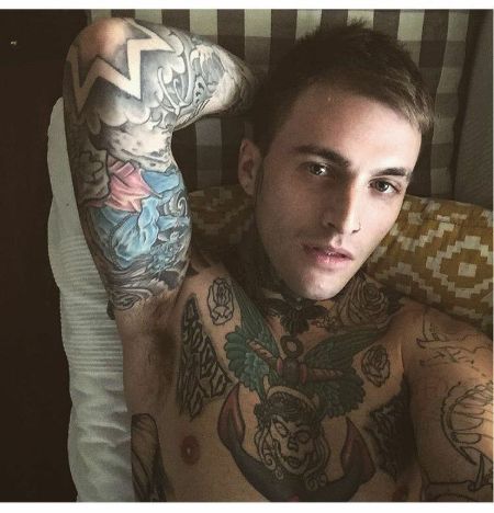 stevens lying down in the couch flexing his tattoos.